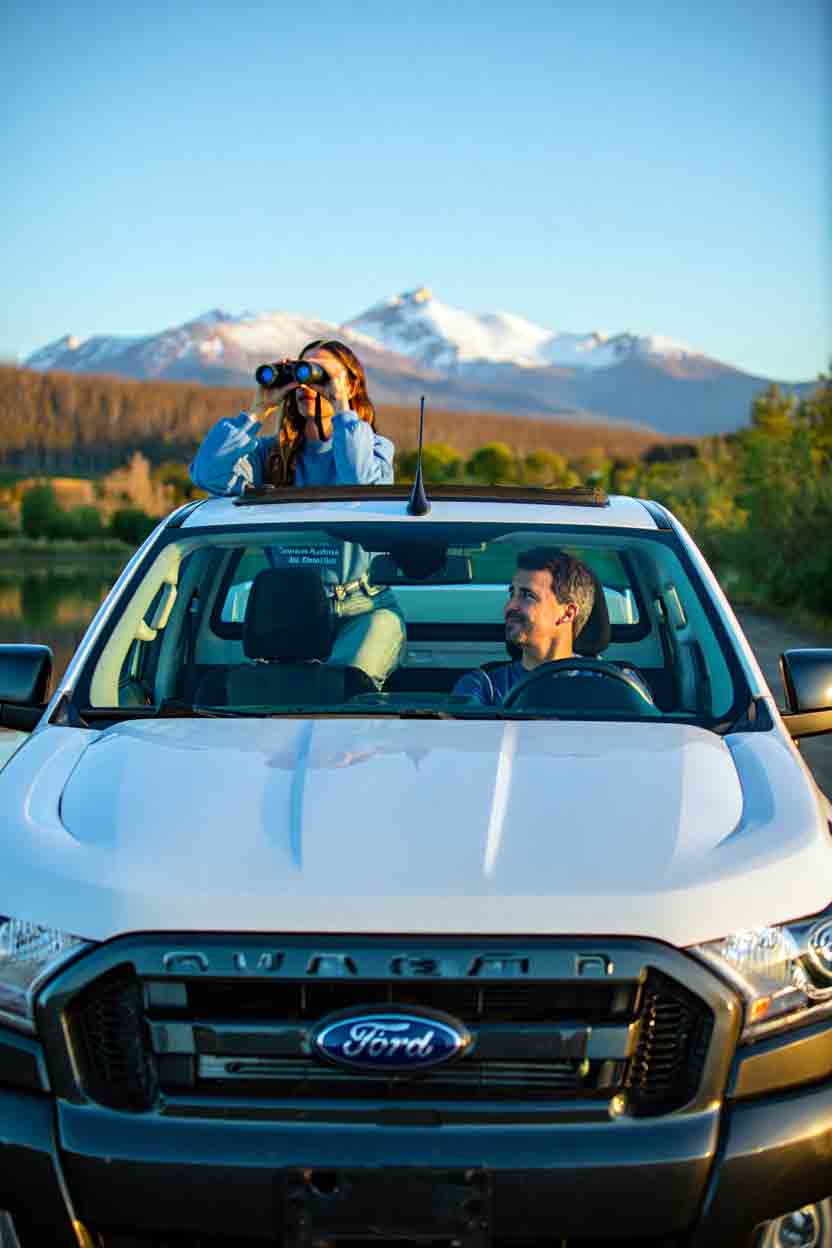 Camioneta Ford Ranger de Diversidad Turismo Activo & de Naturaleza con una pareja disfrutando del paisaje patagónico en Bariloche, combinando rent a car y experiencias de naturaleza.